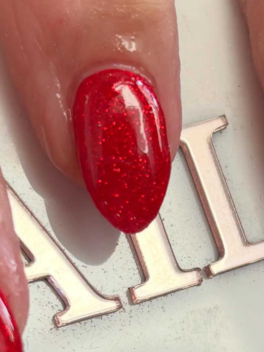 Red glitter gel nail, close up detail
