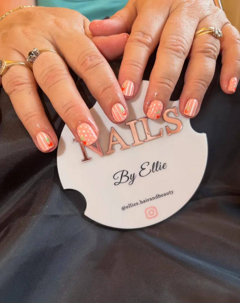 Peach striped nails with cherry and polka dot nail art