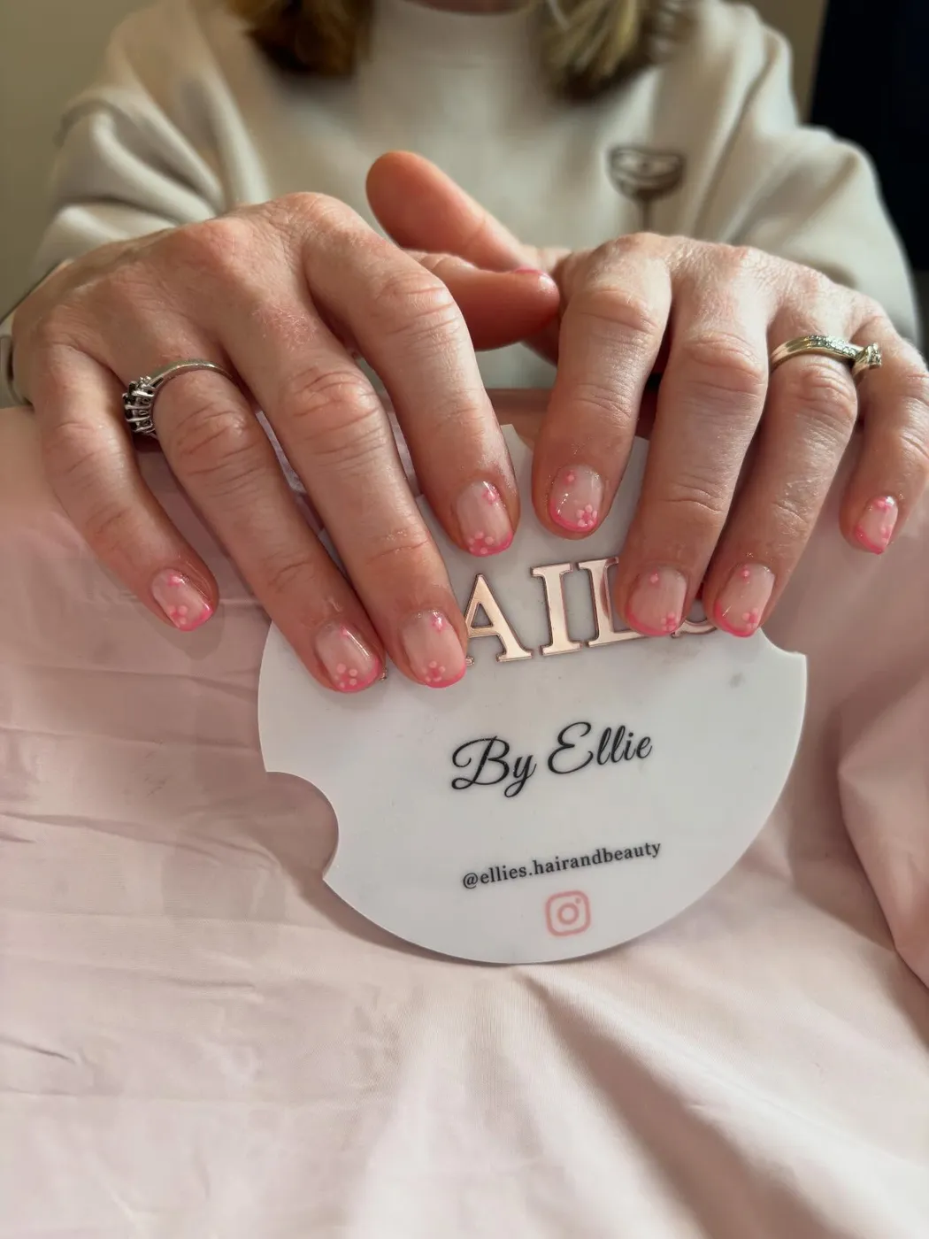 Pink French tip manicure with white polka dot accents